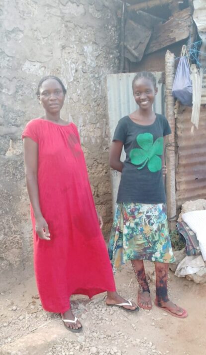 Abigael outside her home with her mum